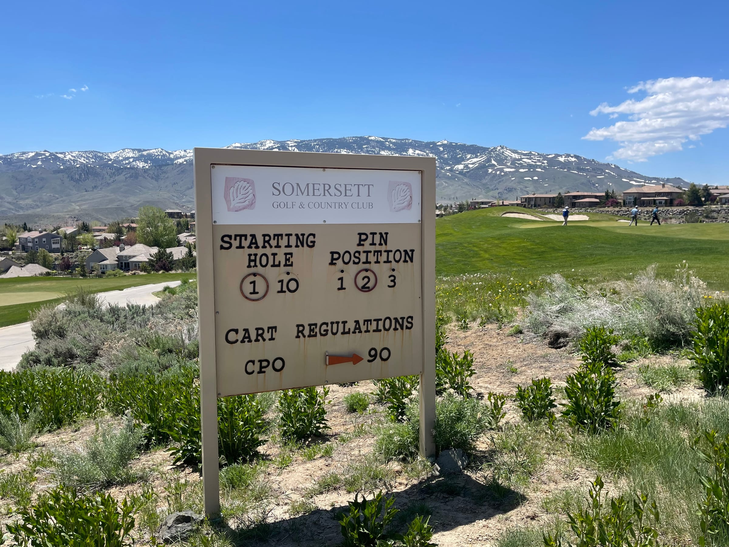 Course signage at Somersett Golf and Country Club, with the green and mountains behind